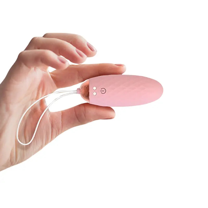 L'œuf vibreur Doris rose clair tenu dans la main, format compact et pratique à emporter partout.