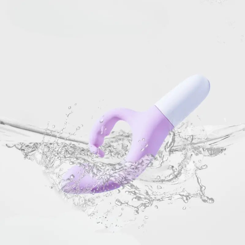Stimulateur waterproof violet plongé dans l’eau, éclaboussures dynamiques