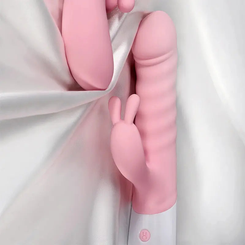 Vibromasseur rabbit rose sur tissu satiné, ambiance douce