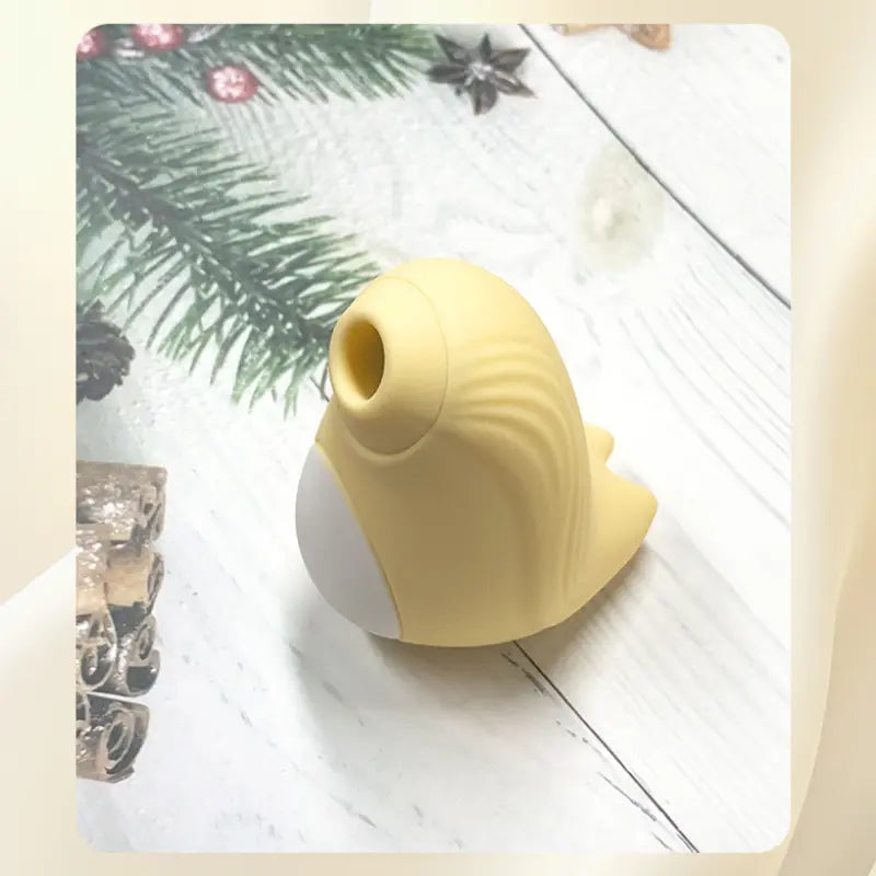 Détail du Stimulateur Penguin jaune posé sur un fond hivernal cosy
