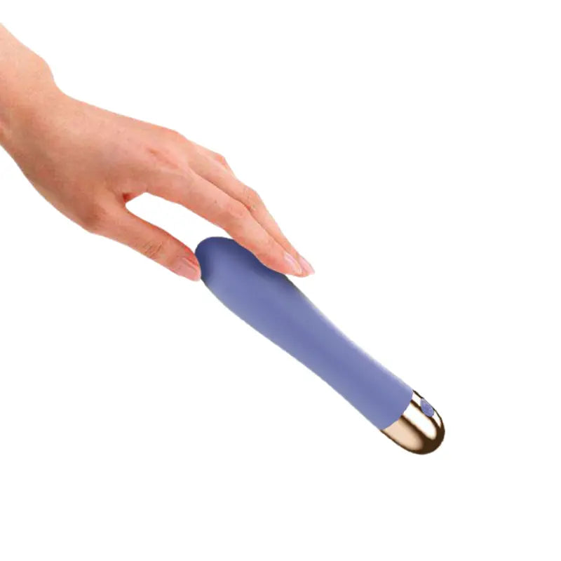 Vibromasseur double moteur tenu en main, montrant sa prise ergonomique et sa finition soignée.